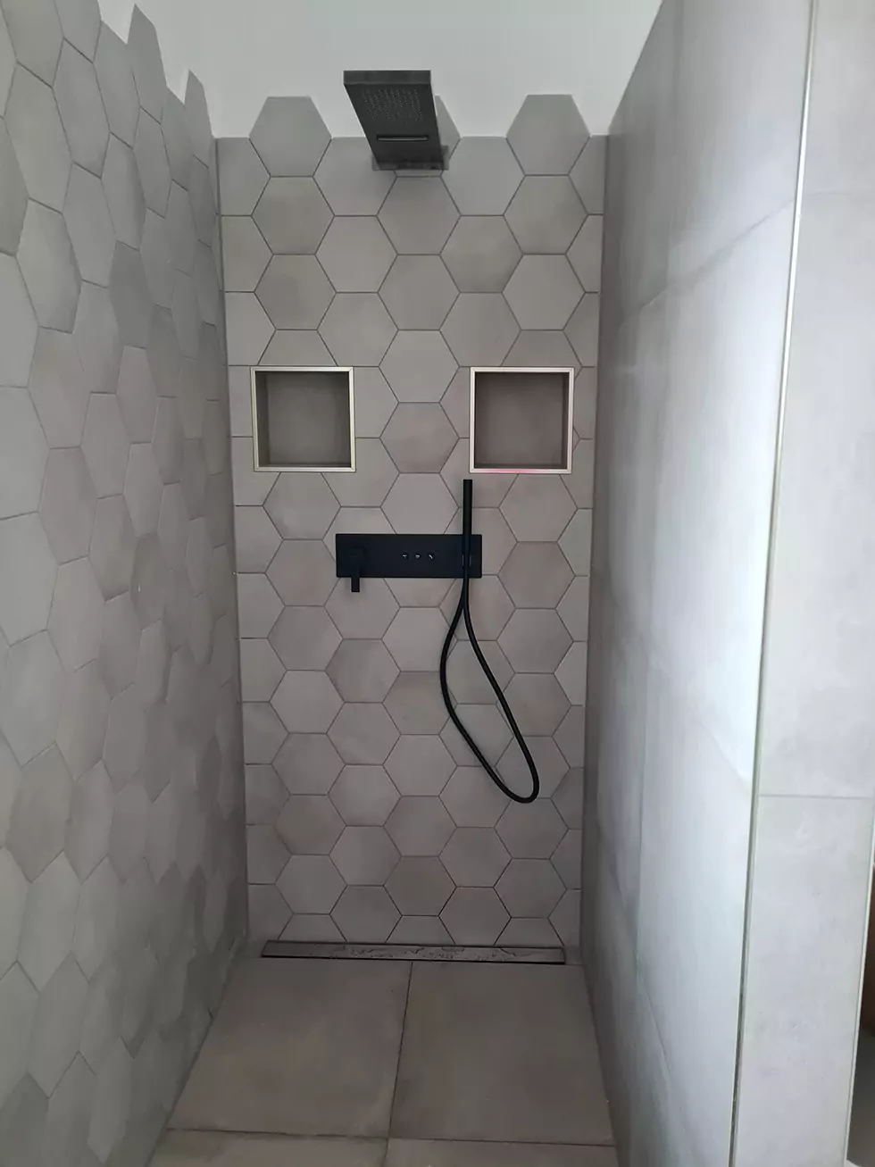 Moderne Dusche mit sechseckigen, grauen Fliesen